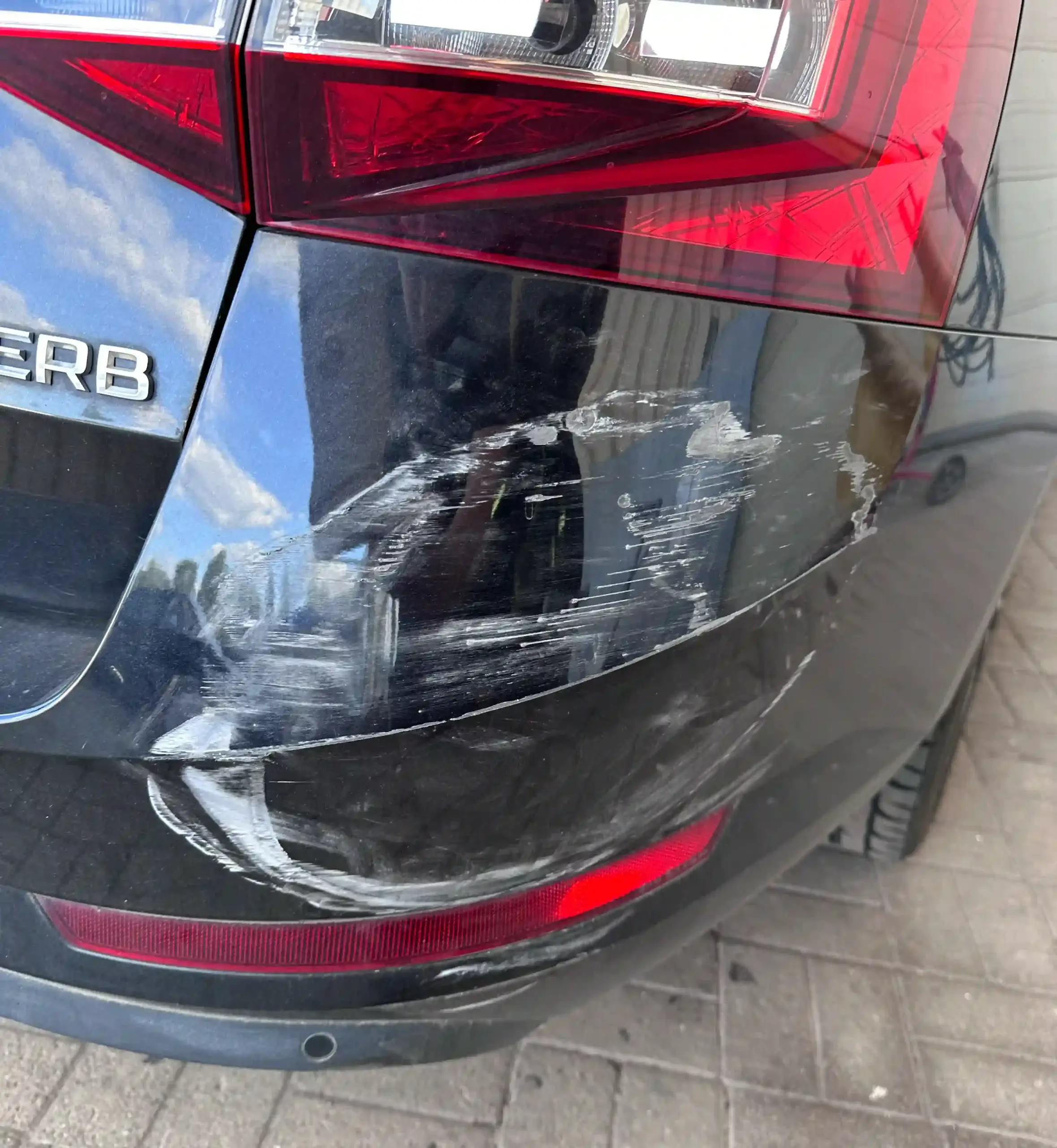 Stoßstangenecke eines schwarzen Škoda Superb mit beschädigtem Stoßfänger – Smart Repair durch die Lackiererei in Schmallenberg für schnelle und präzise Ausbesserungen.