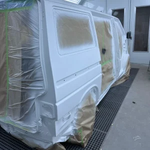 Lackiererei in Schmallenberg. VW T5 nach dem Grundieren in der Lackierkabine – sorgfältige Vorbereitung für die Neulackierung.