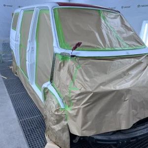 VW T5 im Lackierprozess mit Abdeckfolie und Klarlack – hochwertige Lackierarbeiten in der Lackiererei in Schmallenberg.